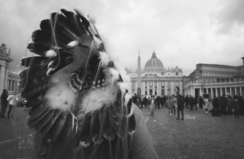A Canadian Indigenous man watches St. Peter's Basilica as he approaches the Vatican for a meeting with Pope Francis. The Pope is expected to apologize to a delegation of Canadian Indigenous for the role of the Catholoc Church in the Residential Schools scandal.