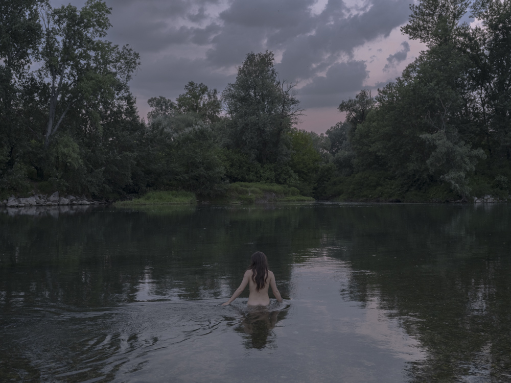 Boffalora D'Adda, Lodi - Una ragazza si bagna sul fiume Adda dopo il tramonto.